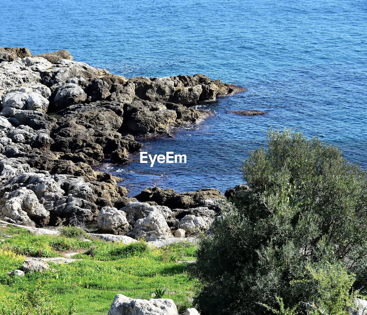 HIGH ANGLE VIEW OF ROCKS ON SEA