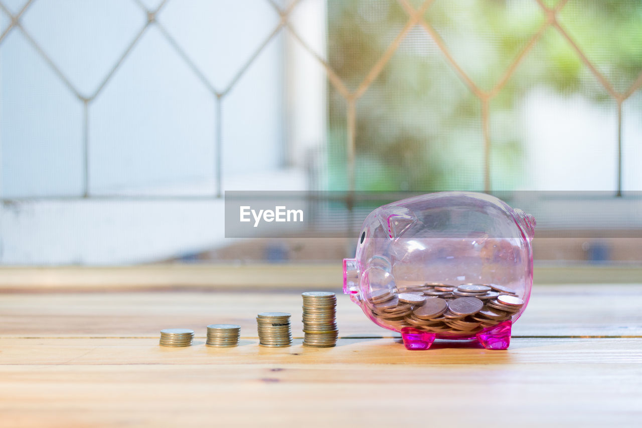 Close-up of piggy bank and coins on table