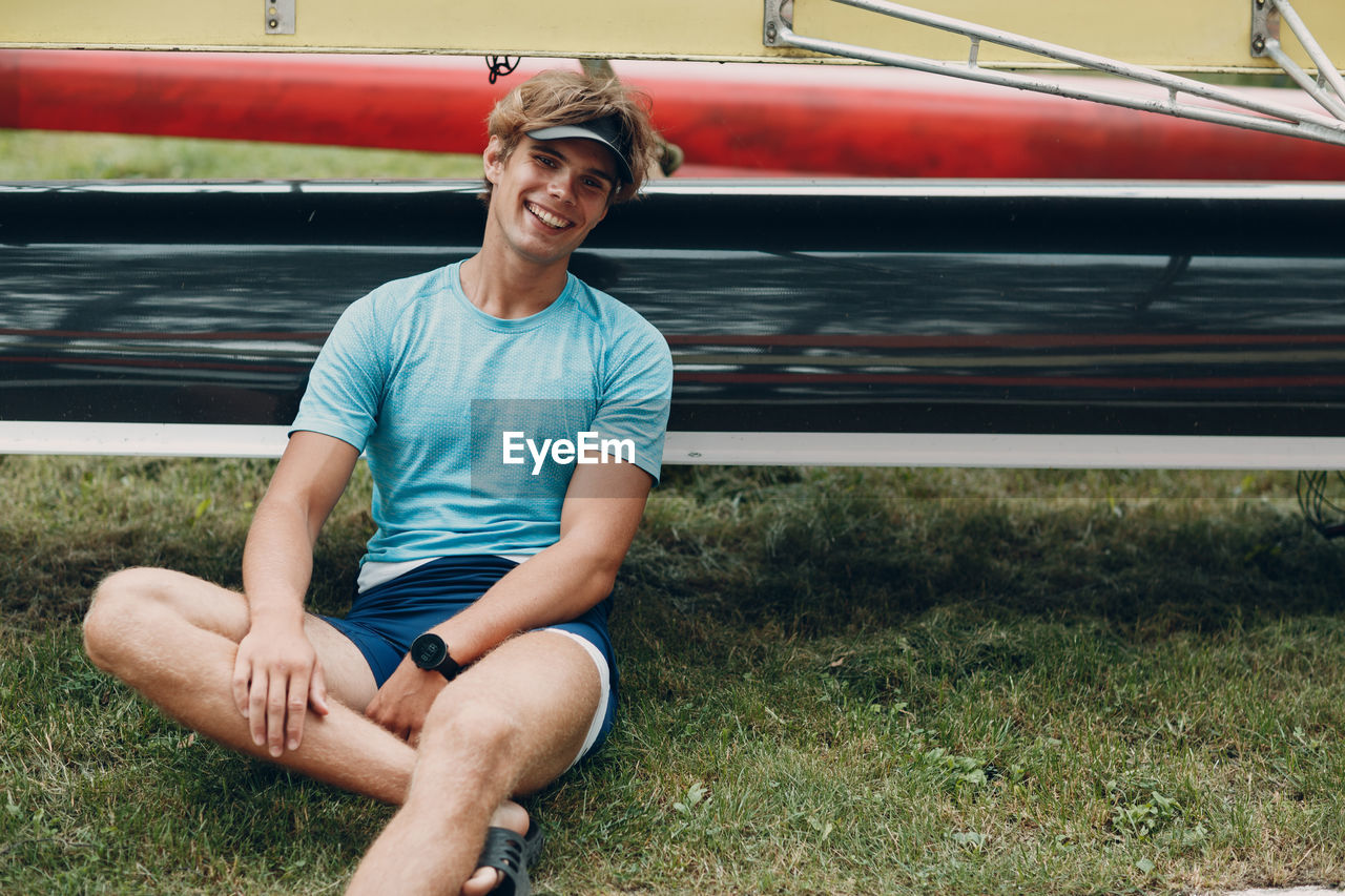 Portrait of smiling young man sitting on grass