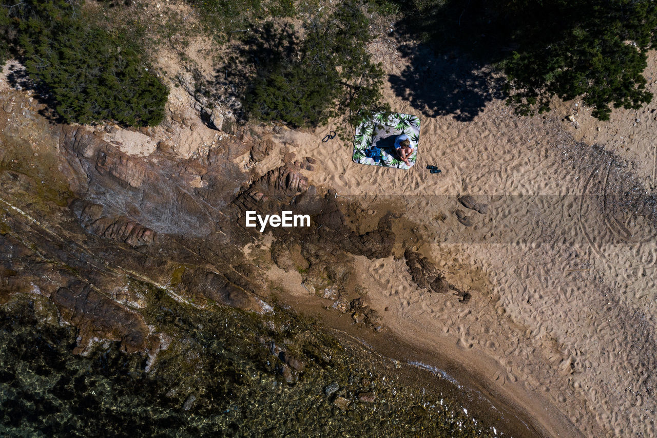 HIGH ANGLE VIEW OF MAN ON ROCKS