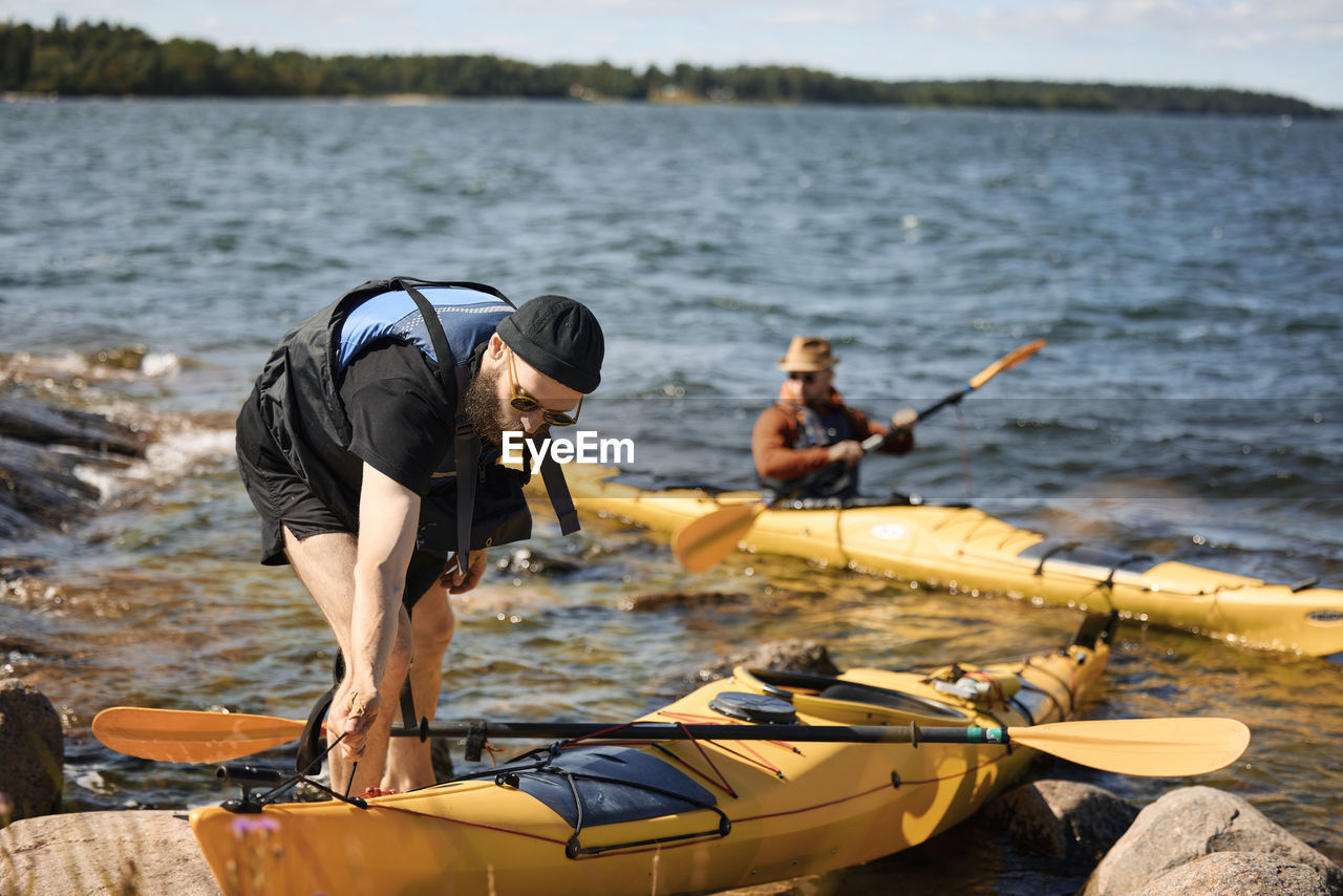 Man at sea standing near kayak