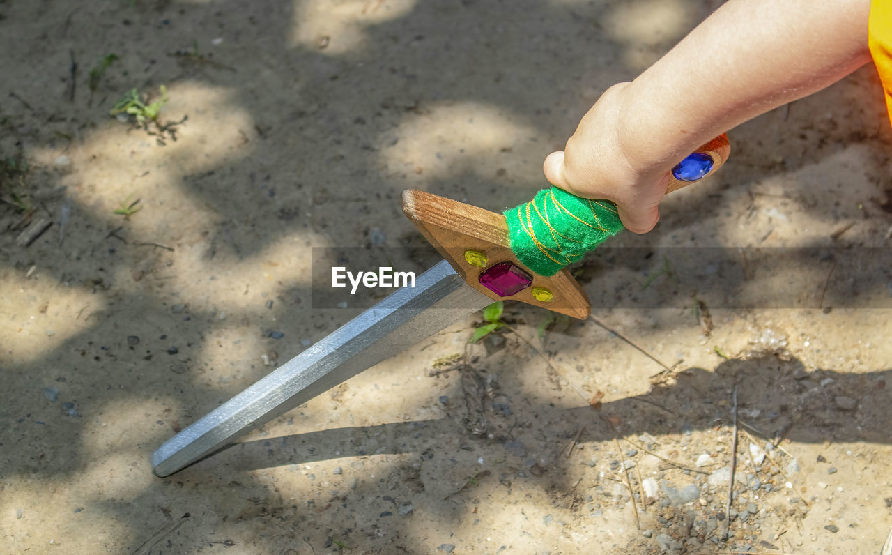 Cropped hand holding toy sword