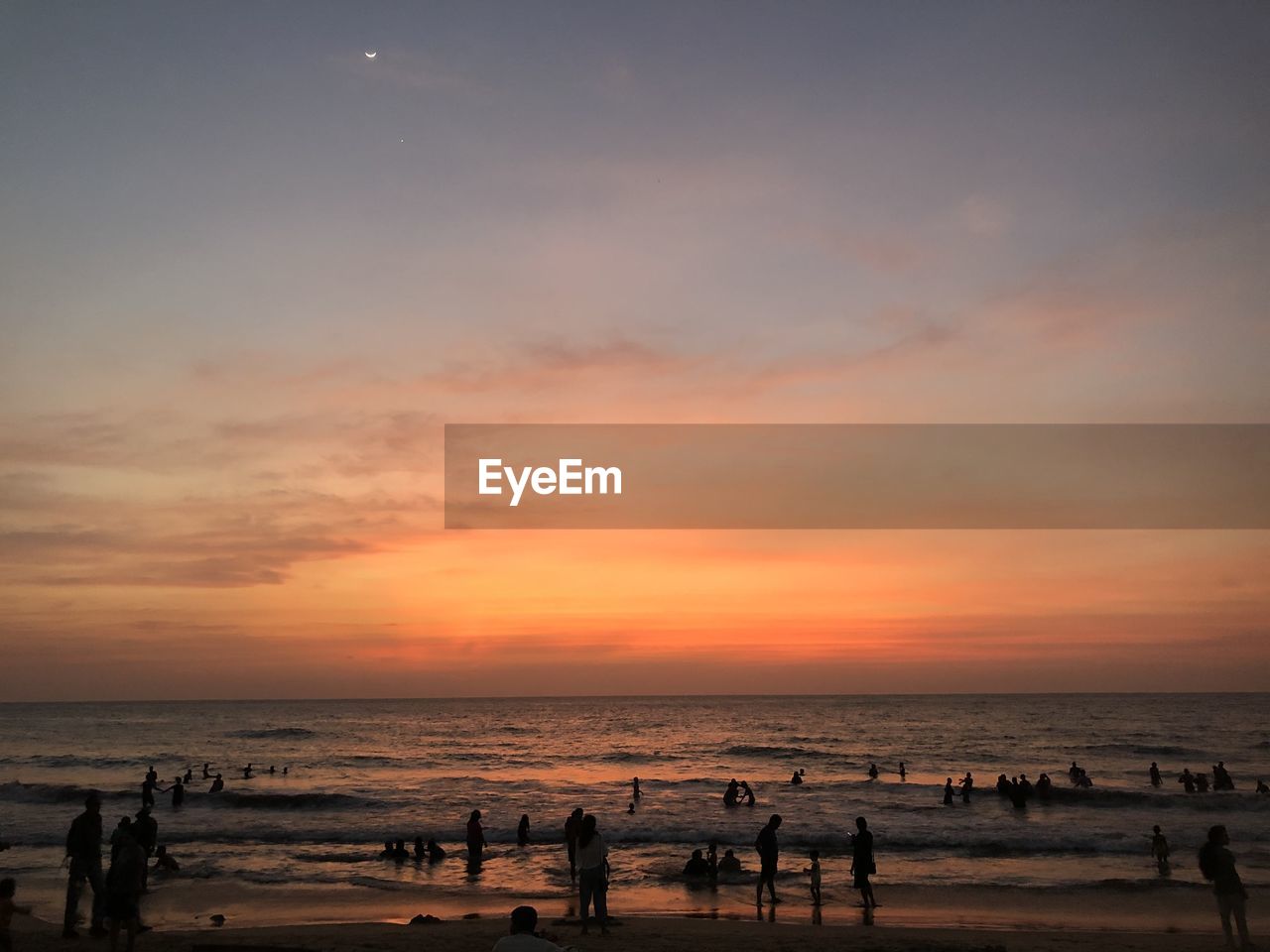 Group of people on beach during sunset