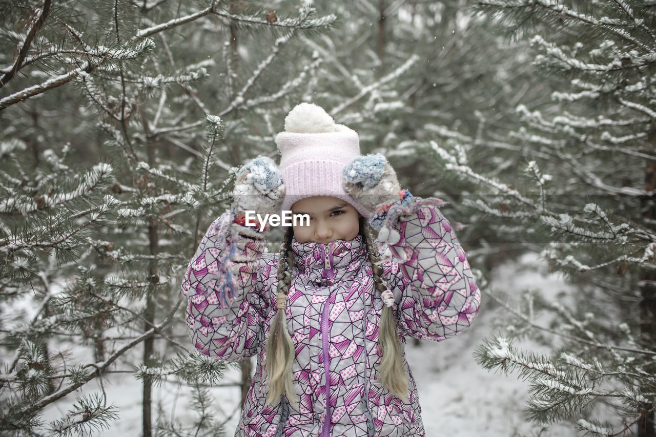 rear view of woman standing on snow covered field