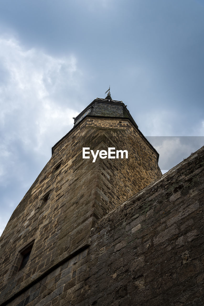Low angle view of old tower in dinan against sky