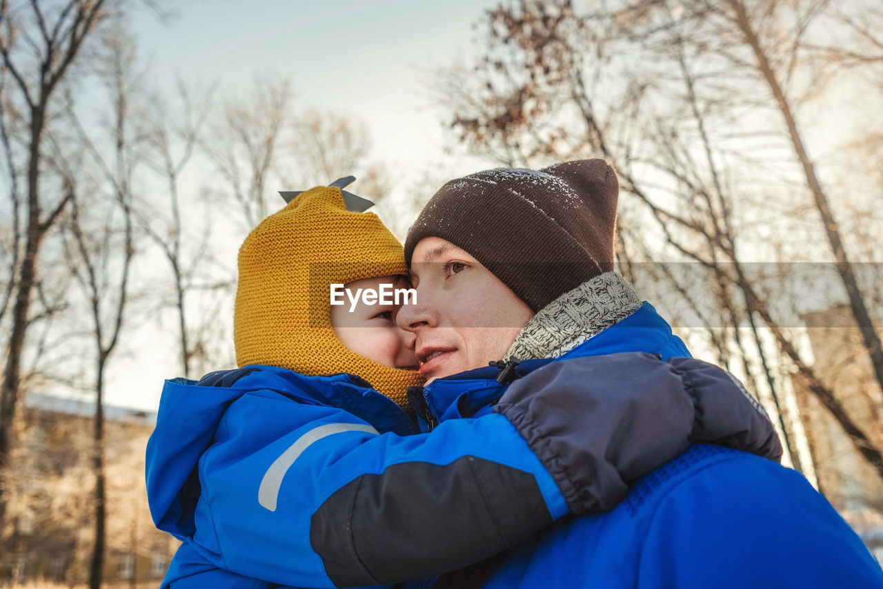 Close-up of father and son embracing outdoors duding winter