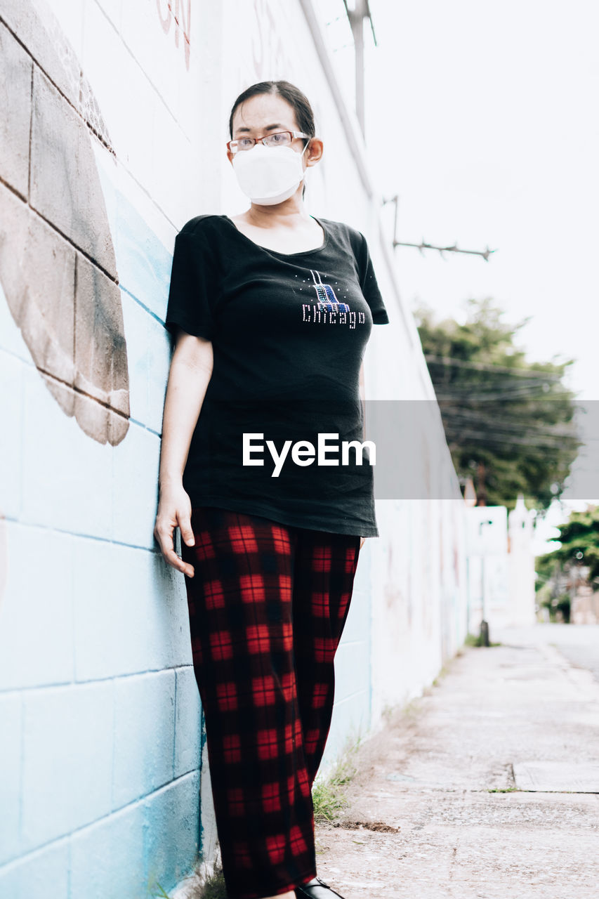one person, fashion, pattern, adult, portrait, spring, clothing, standing, young adult, red, looking at camera, photo shoot, front view, white, glasses, full length, day, architecture, women, casual clothing, dress, cool attitude, individuality, black, outdoors, city, lifestyles, tartan, arts culture and entertainment