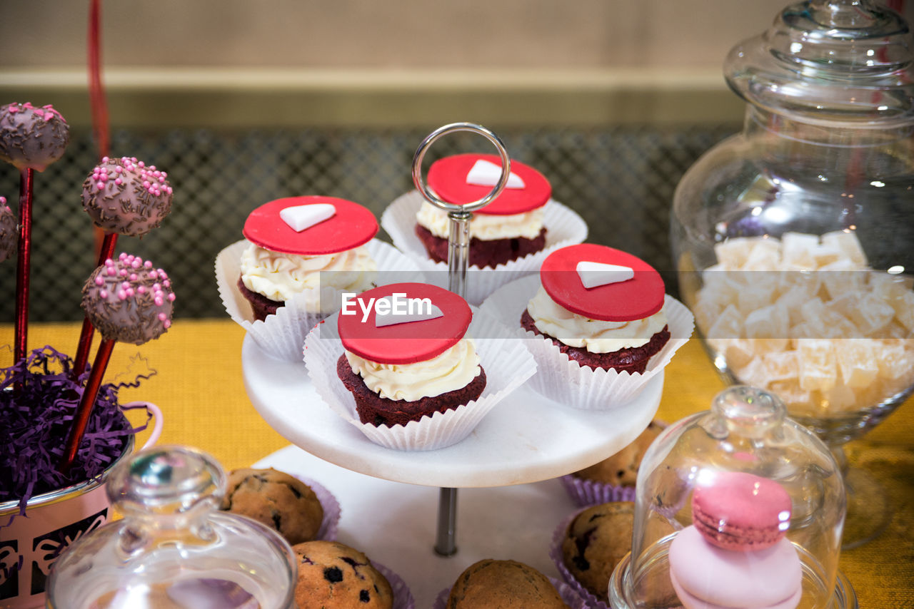 CLOSE-UP OF CUPCAKES ON TABLE AGAINST WALL