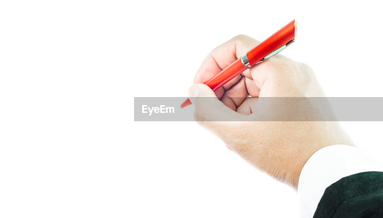 Close-up of hand holding pen over white background