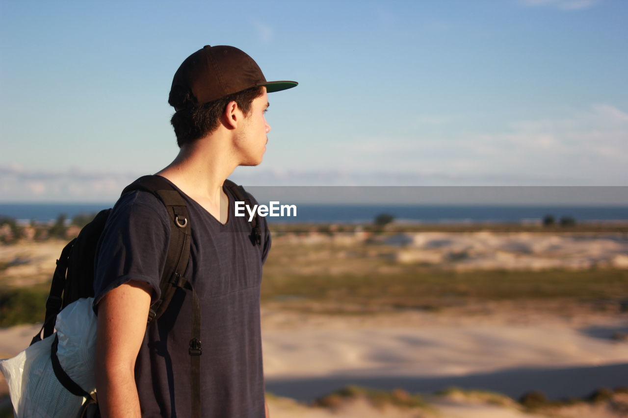 Close-up of man wearing sunglasses standing on beach