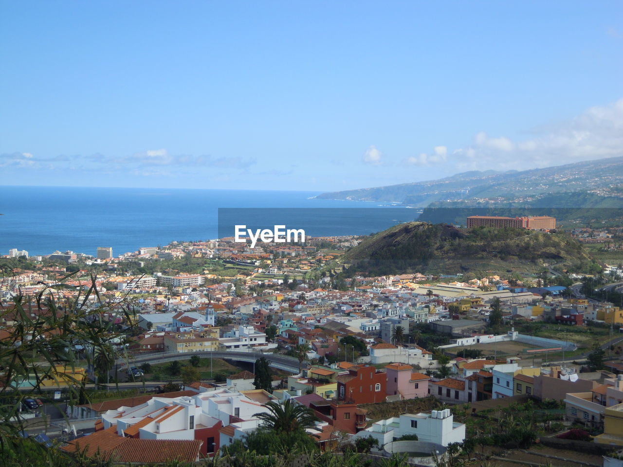 HIGH ANGLE SHOT OF TOWNSCAPE BY SEA AGAINST SKY