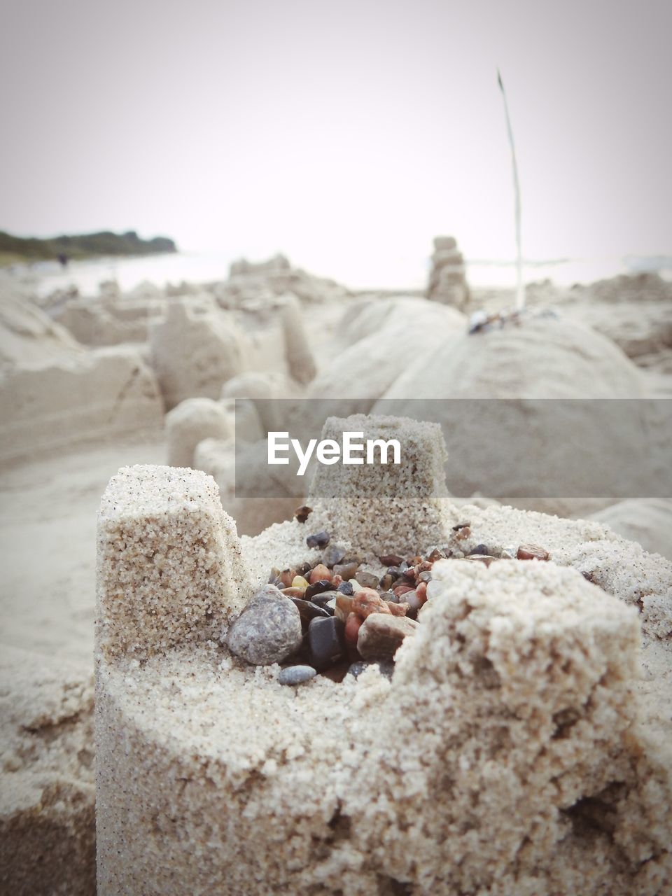 CLOSE-UP OF PEBBLES ON SAND AT BEACH