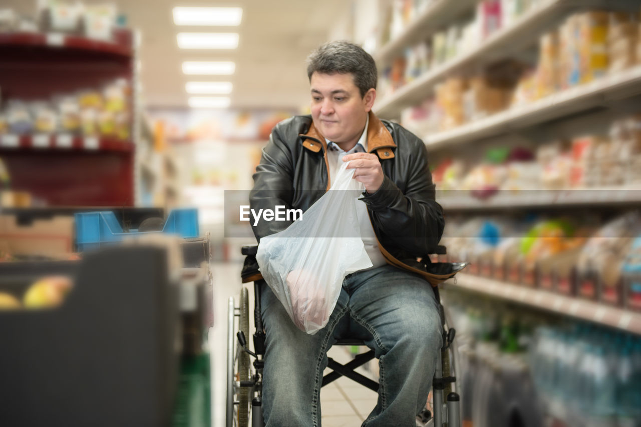 A disabled person in a wheelchair buys groceries