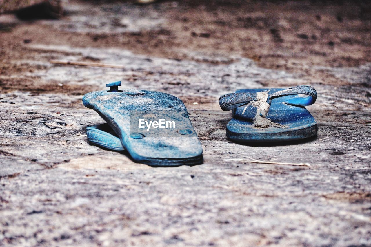 Close-up of old slippers on ground