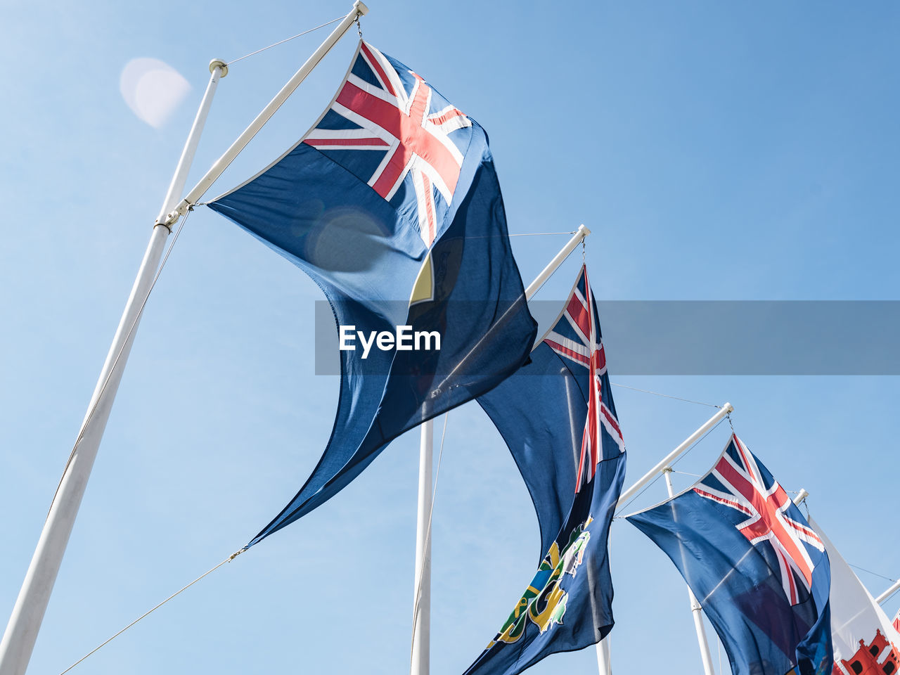 Low angle view of flags against blue sky