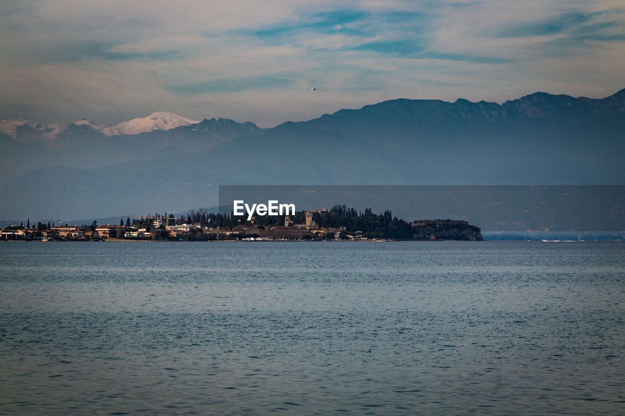 Scenic view of sea by buildings against sky