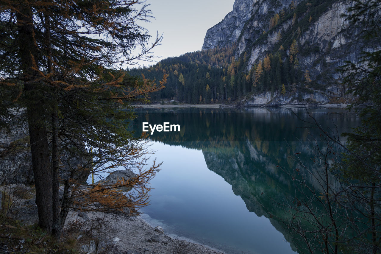 Scenic view of lake by trees against sky in dolomites mountains 