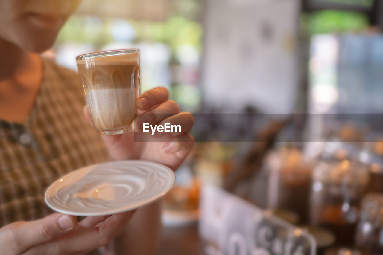 Beautiful speculoos latte with milk in a glass ,cafe background.