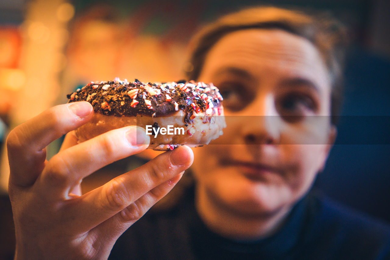 Woman holding dessert while sitting at restaurant