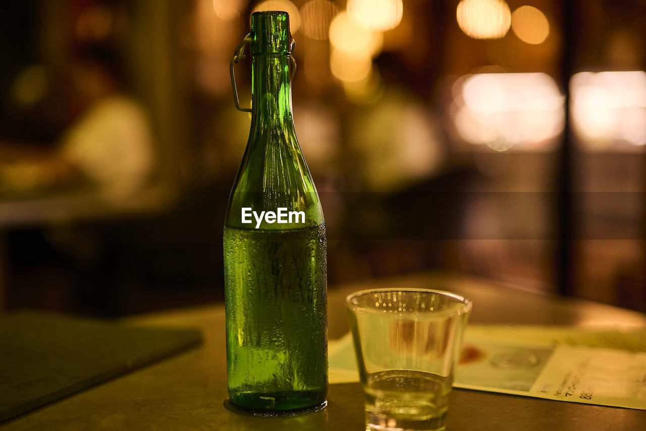 Close-up of glass and bottle on table