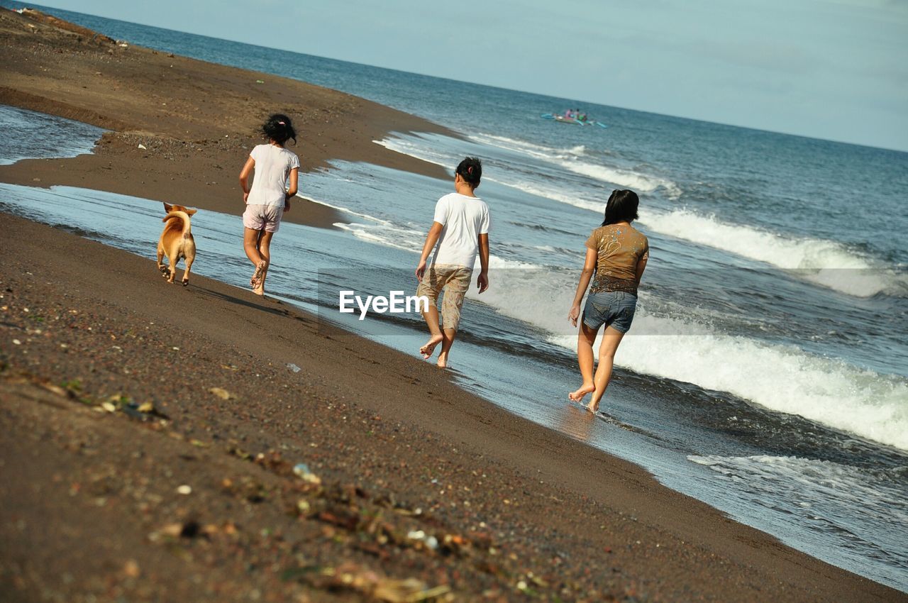 PEOPLE WALKING ON BEACH