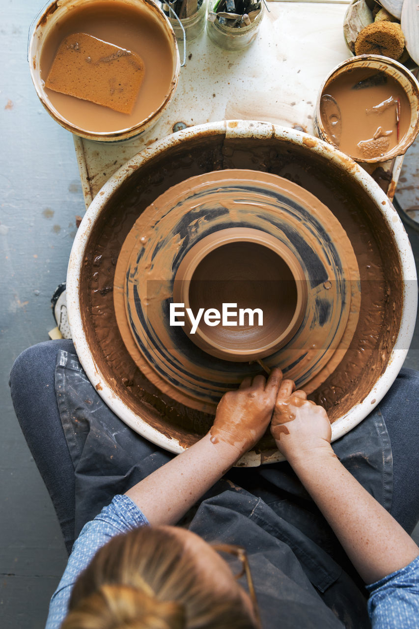 Overhead view of woman working on pottery wheel