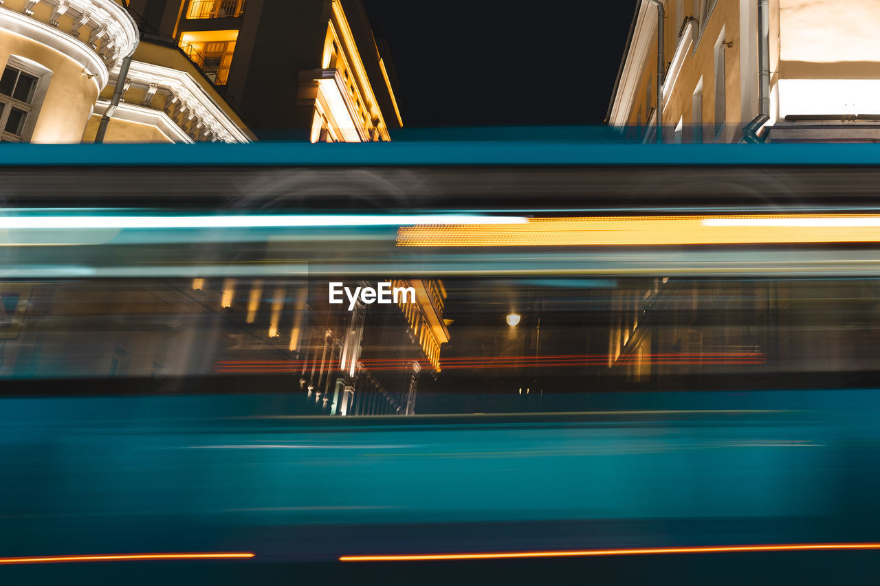 BLURRED MOTION OF TRAIN AT ILLUMINATED RAILROAD STATION