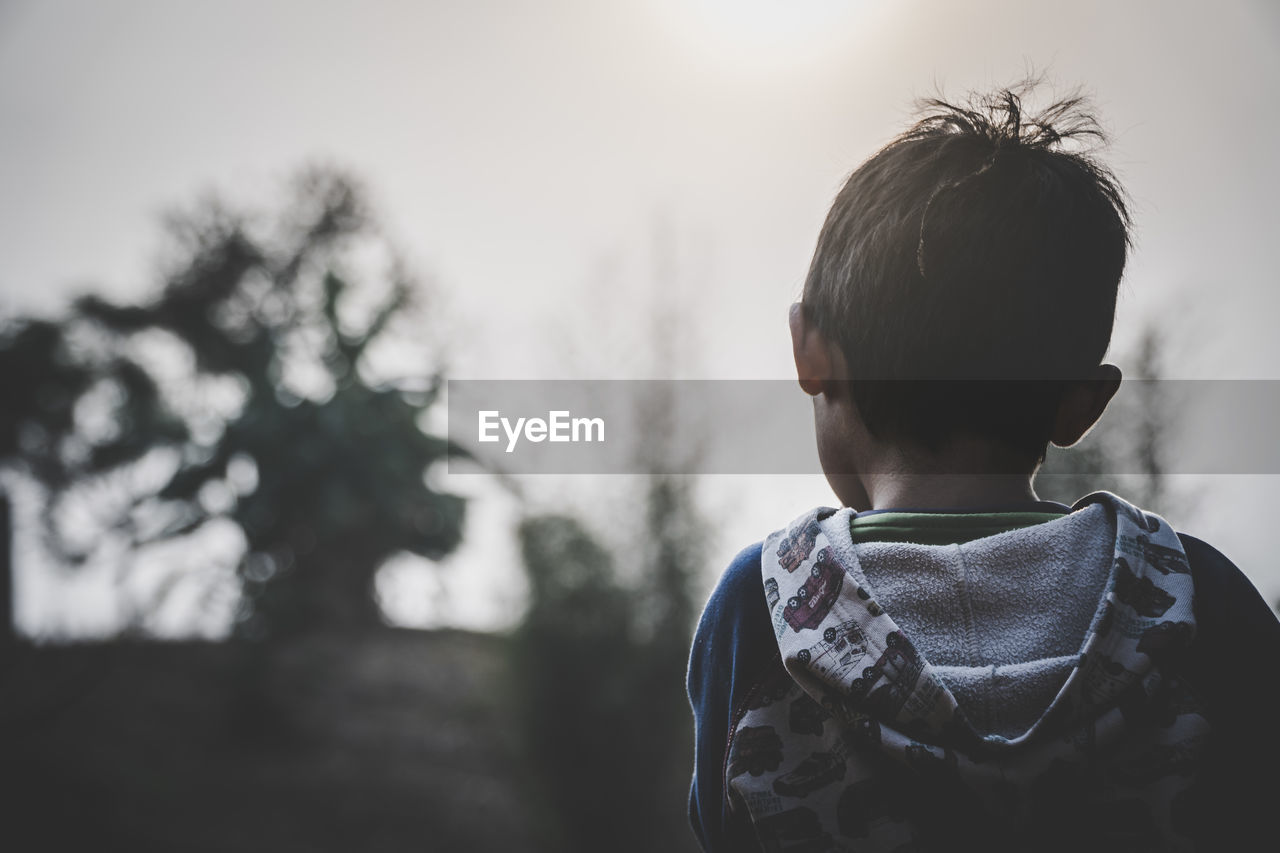 REAR VIEW OF BOY LOOKING AT VIEW