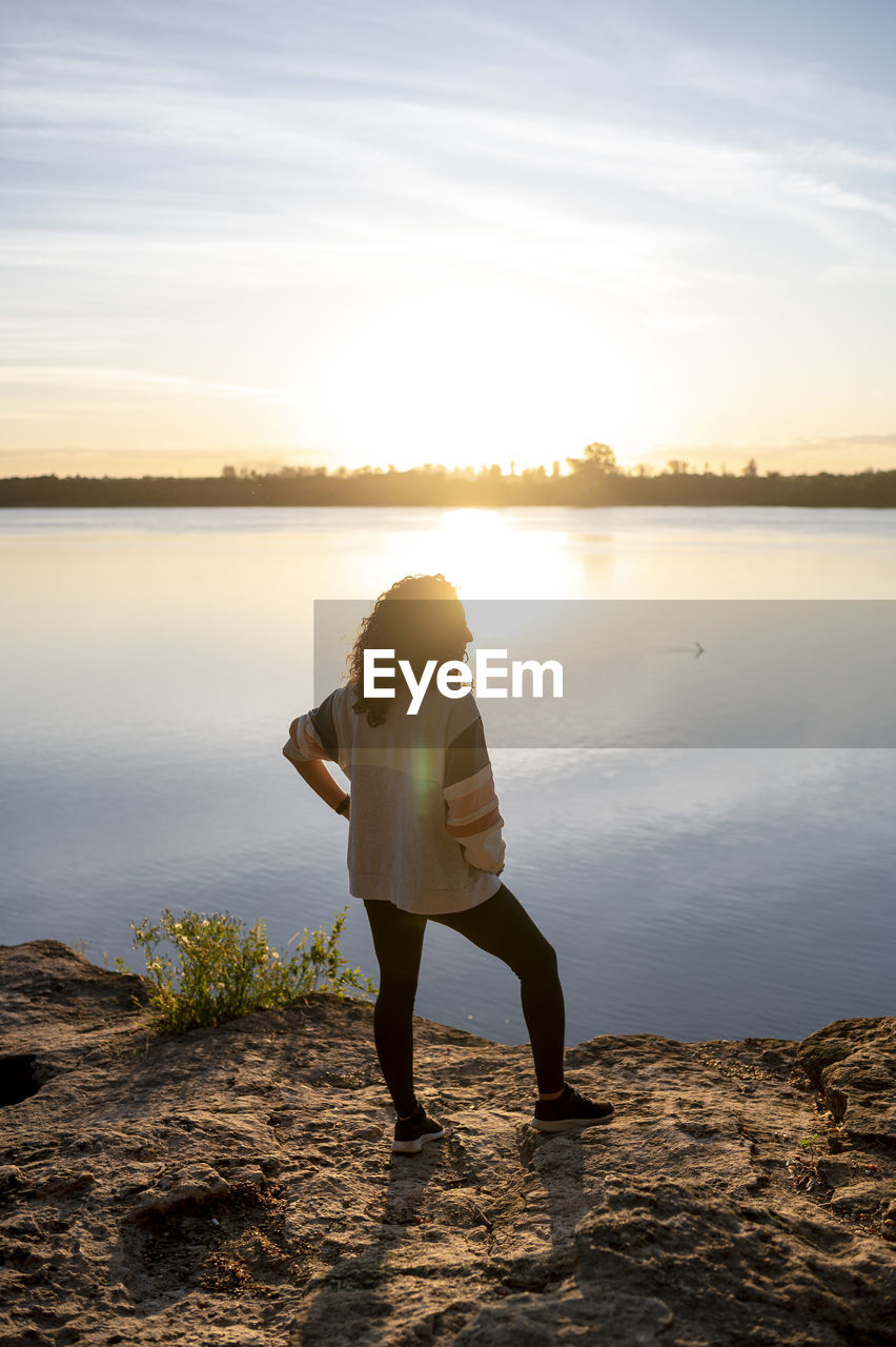 Traveler woman walking by the lake during sunset.