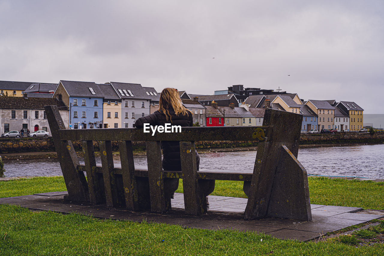 Girl enjoying view from a bench in galwey, ireland