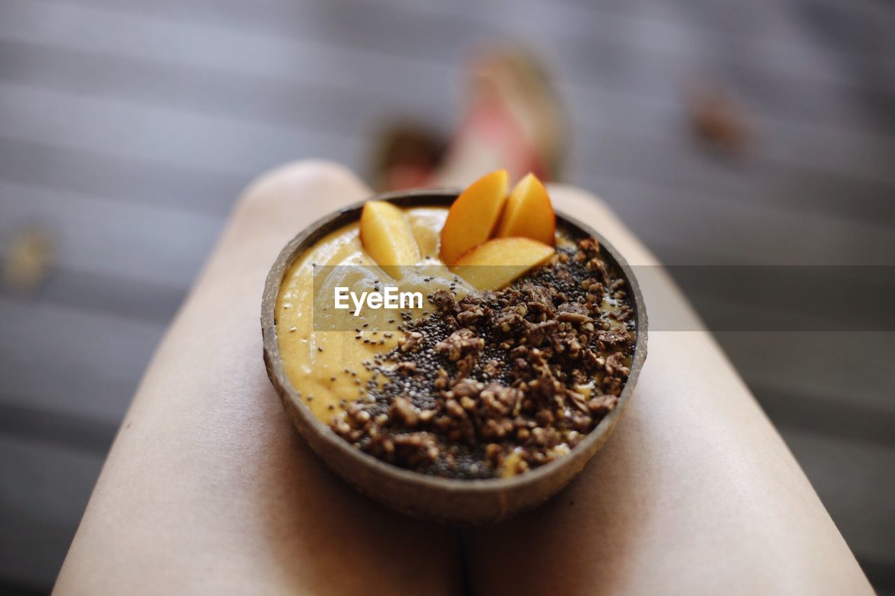 Low section of woman with food in bowl at home