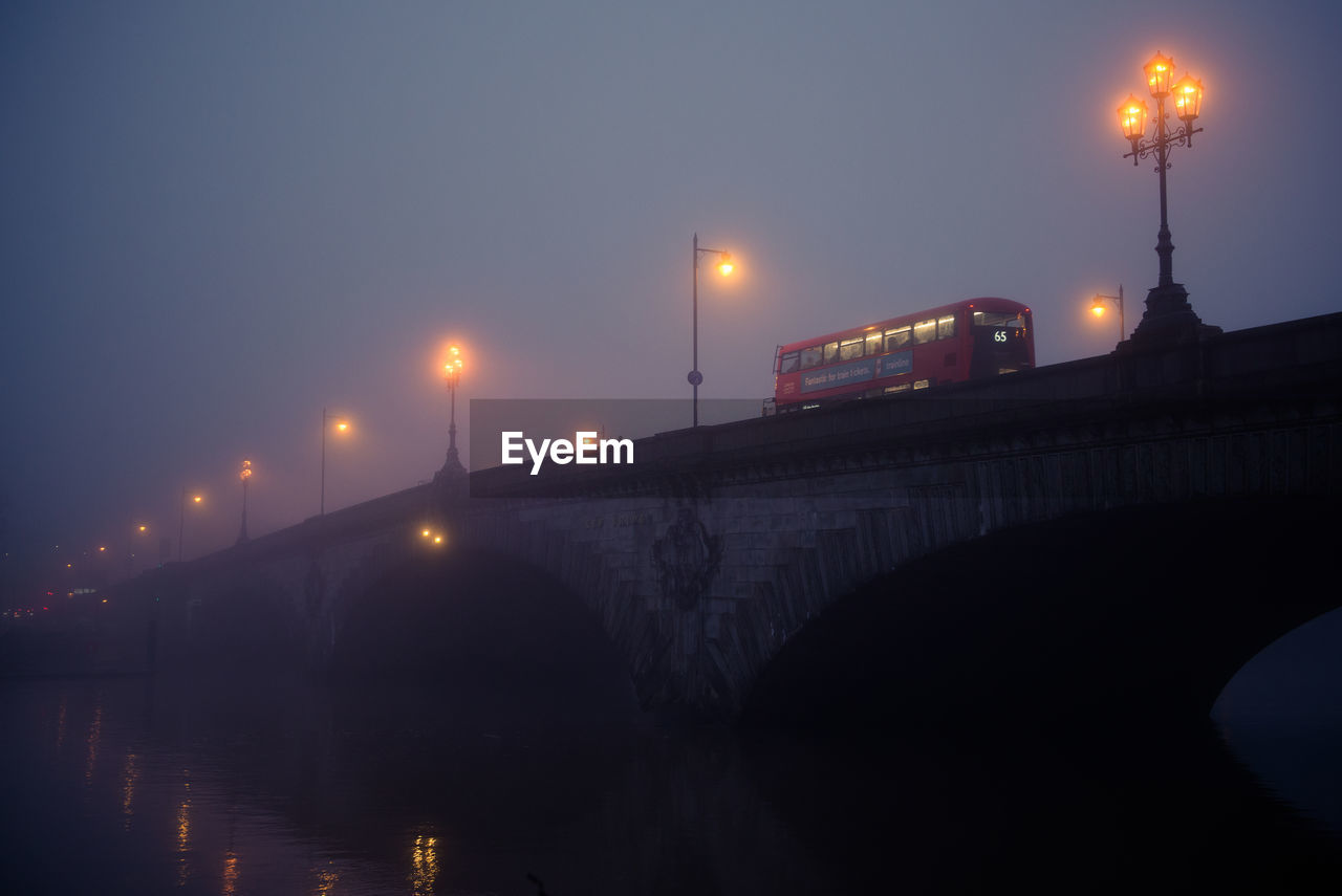 ILLUMINATED BRIDGE AGAINST SKY DURING NIGHT