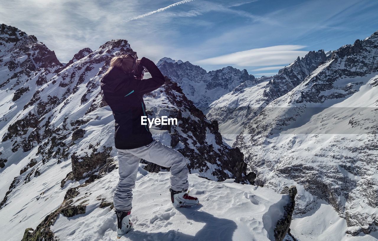 Side view of woman standing on snowcapped mountain