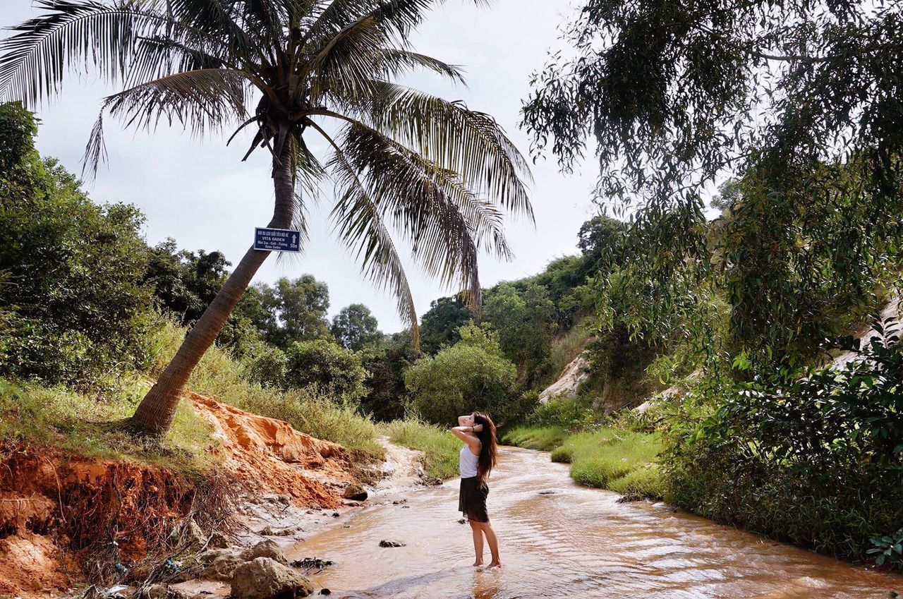 Side view of young woman standing in stream