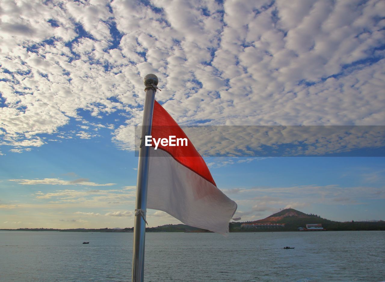 RED FLAG ON SEA AGAINST SKY