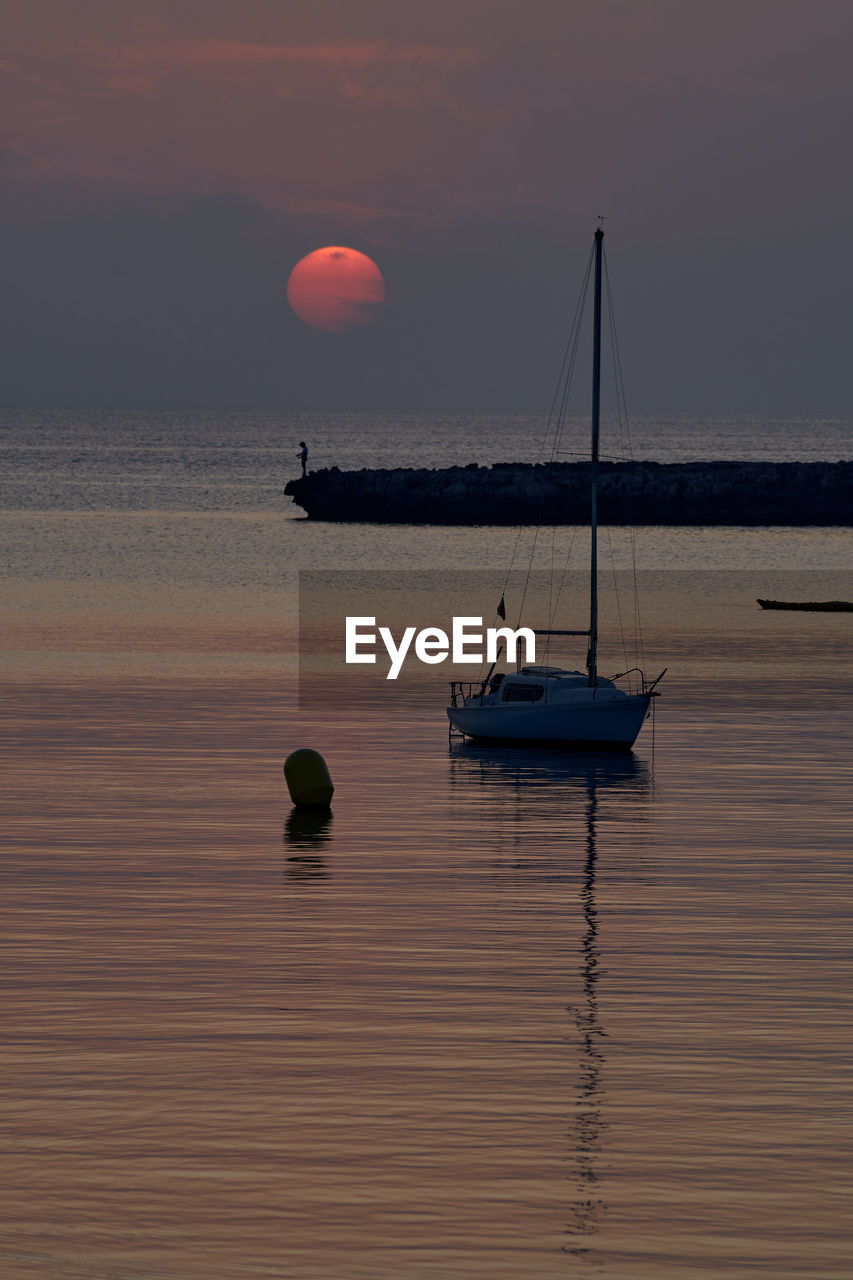 SAILBOATS ON SEA AGAINST SKY DURING SUNSET