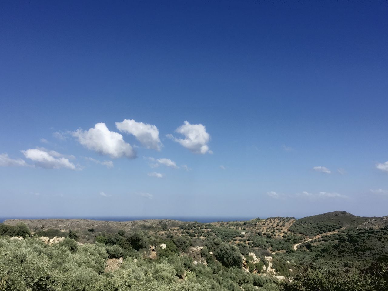 SCENIC VIEW OF ARID LANDSCAPE AGAINST BLUE SKY