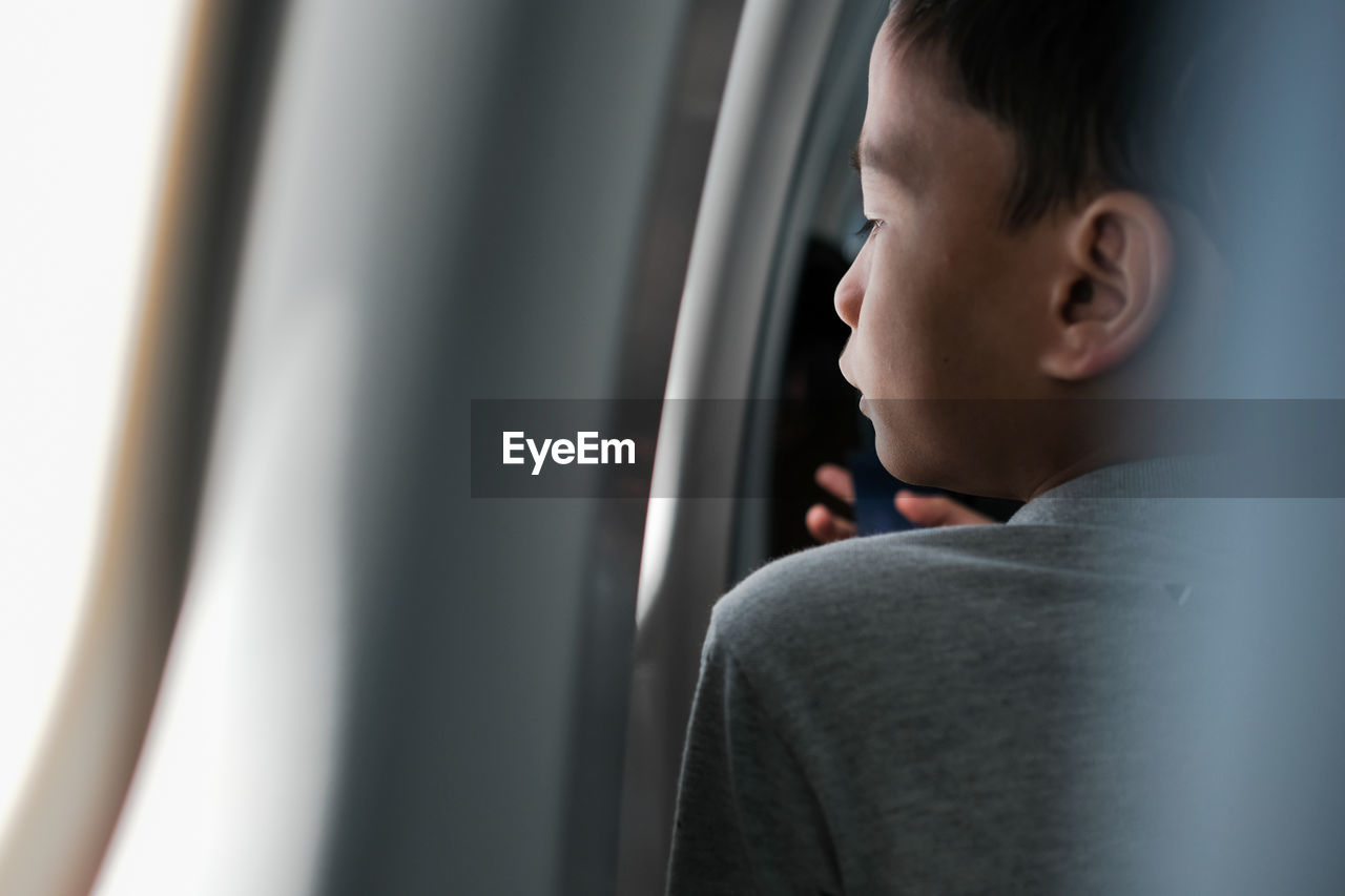 Boy looking through window