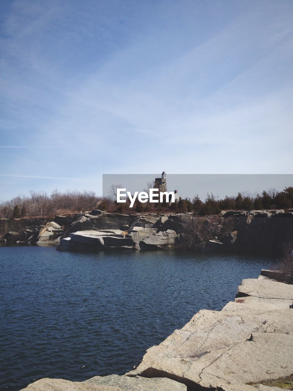 Rocks by lake against sky