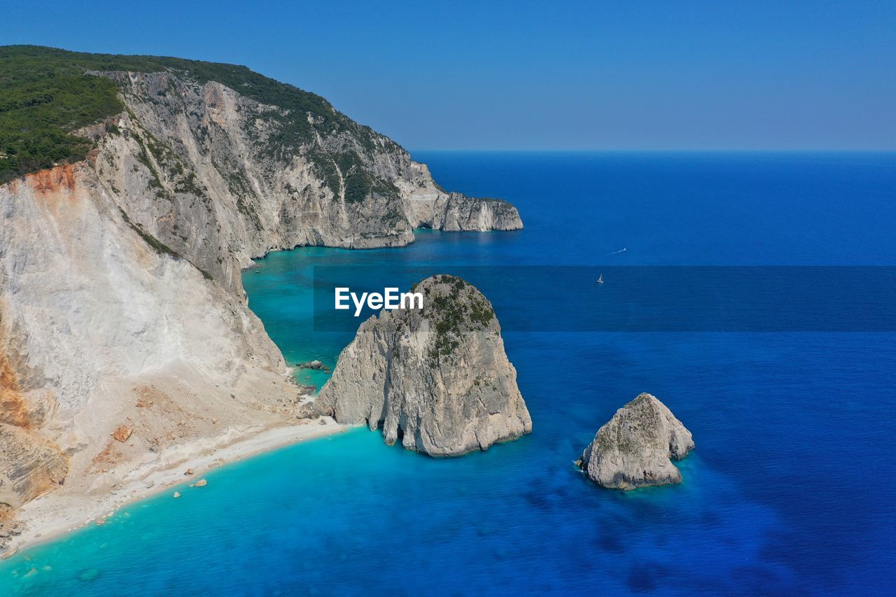 Panoramic view of rocks and sea against blue sky