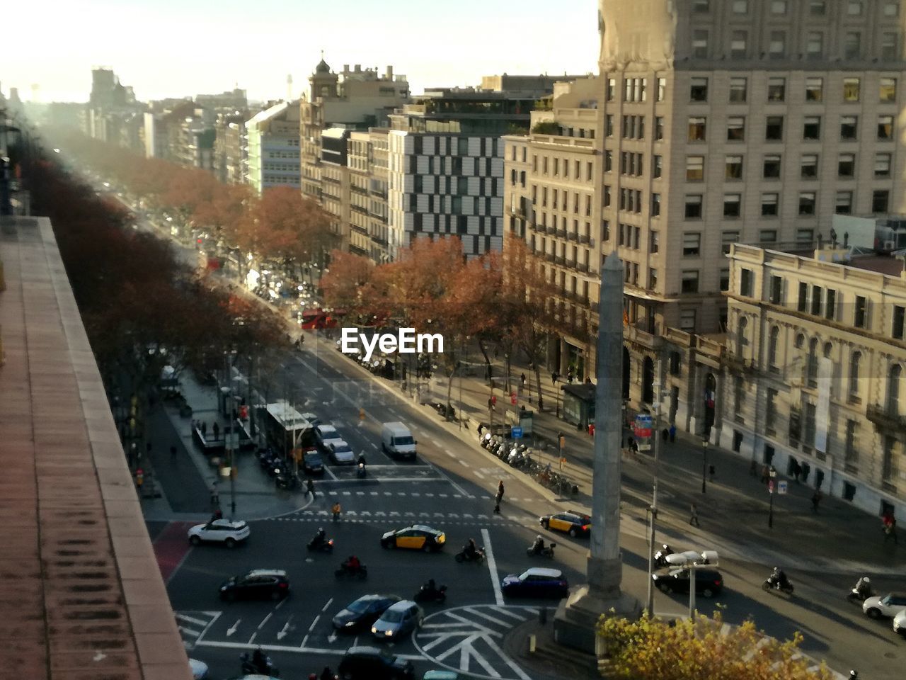 HIGH ANGLE VIEW OF VEHICLES ON ROAD ALONG BUILDINGS