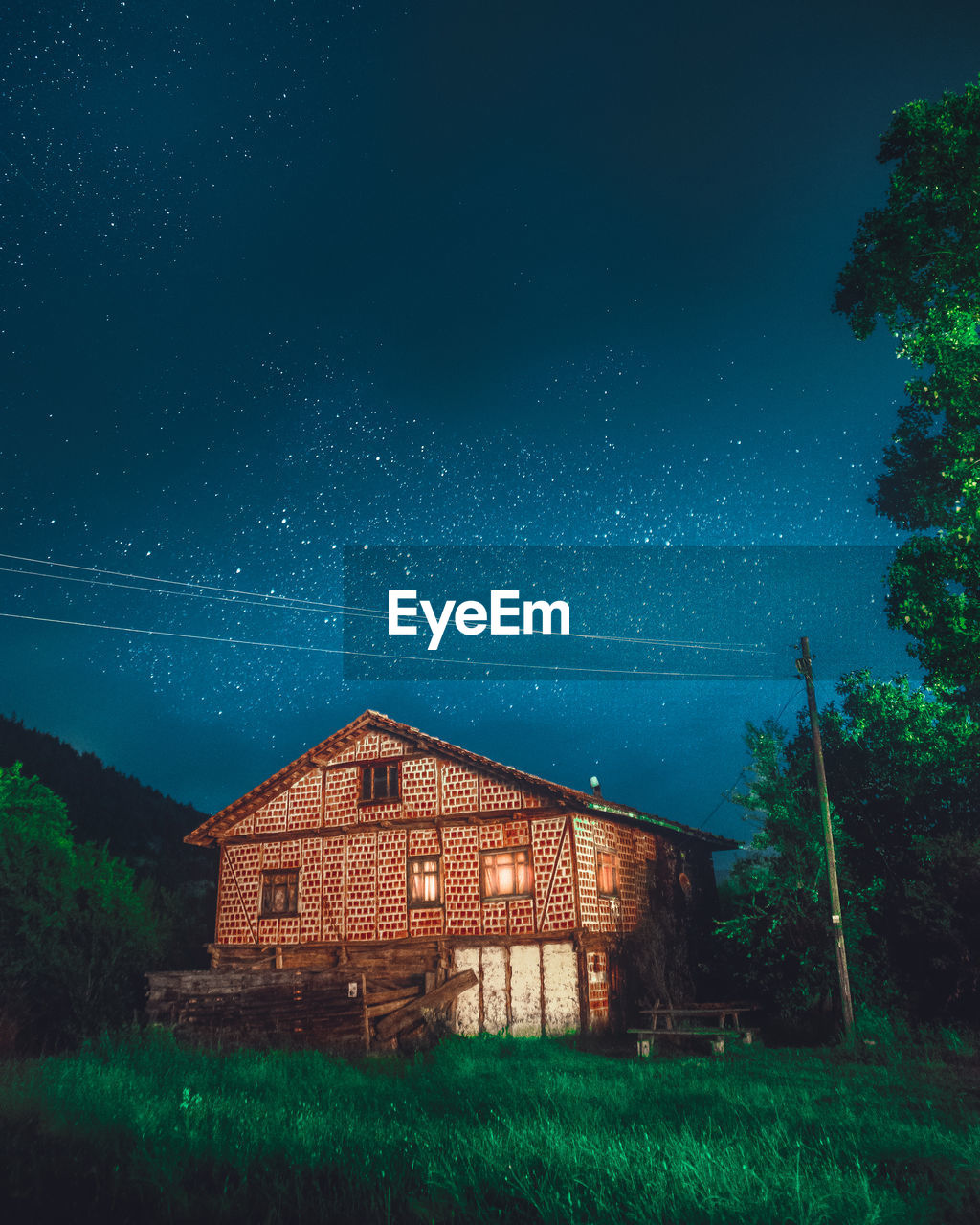 HOUSE ON FIELD AGAINST CLEAR SKY AT NIGHT