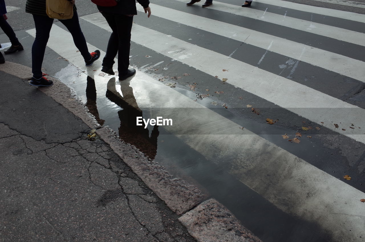 Low section of people walking on road