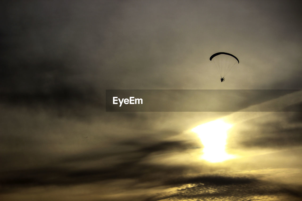 LOW ANGLE VIEW OF SILHOUETTE FLYING AGAINST SKY