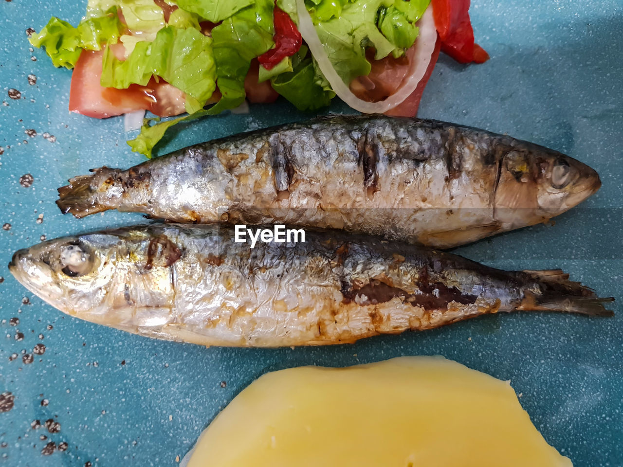 Top view of roasted sardine with salad and boiled potatoes. portugal typical cuisine