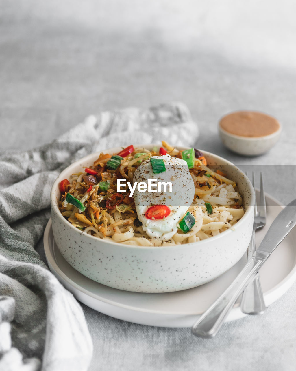 Close-up of noodles with poached egg served in bowl on table