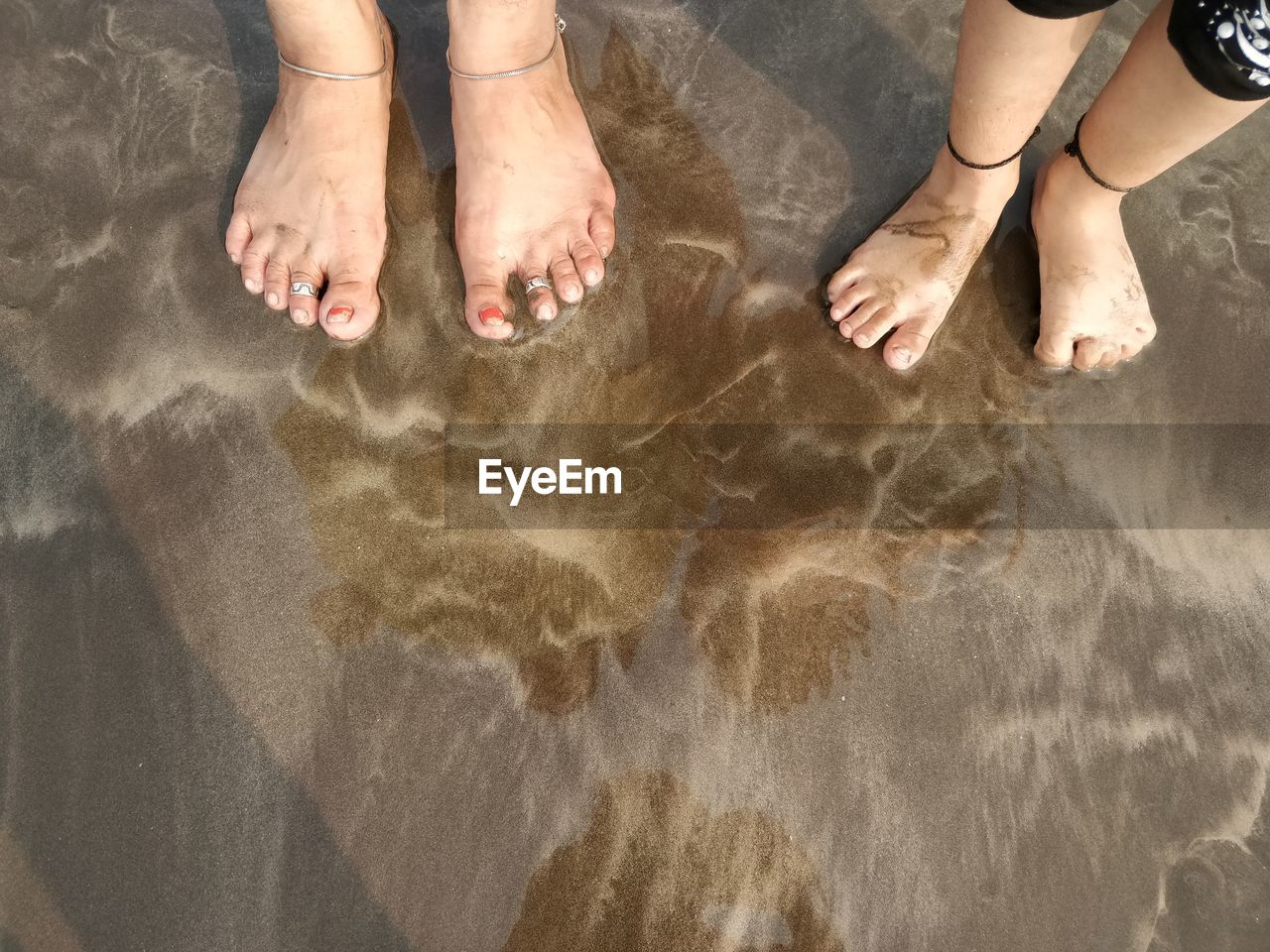 LOW SECTION OF PEOPLE STANDING ON BEACH