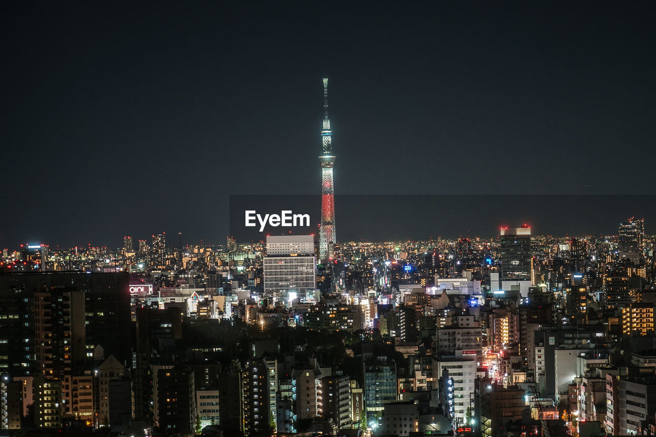 ILLUMINATED CITY BUILDINGS AT NIGHT