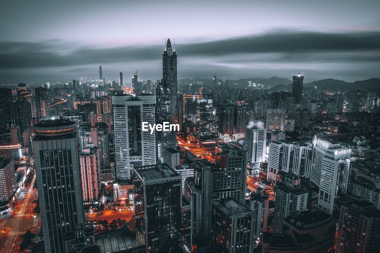 Illuminated cityscape against sky at night