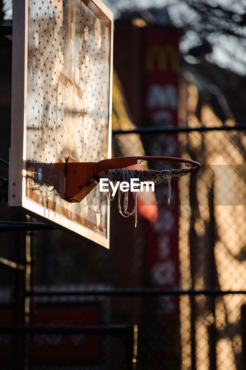 Close-up of basketball hoop against fence